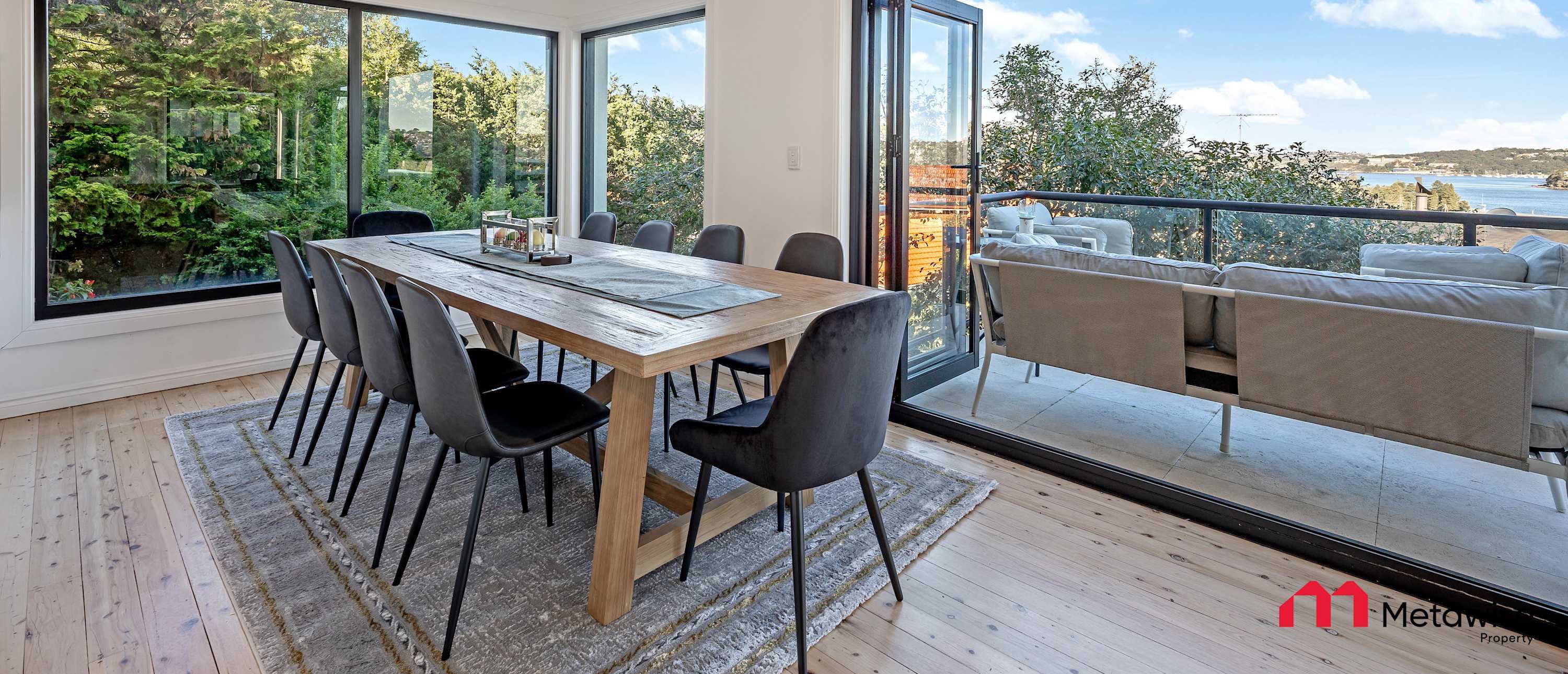 Dining room of a MetaWise-managed home in Seaforth, doors open to the balcony and the water.