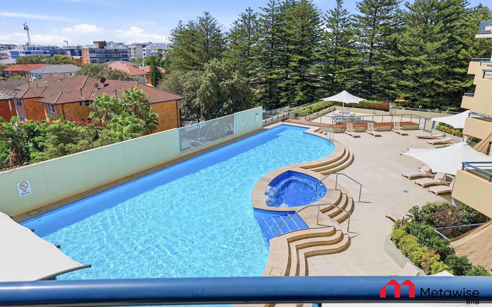 Resort-style pool at a Cronulla apartment building where MetaWise manages apartments, Norfolk pines and the beach behind.