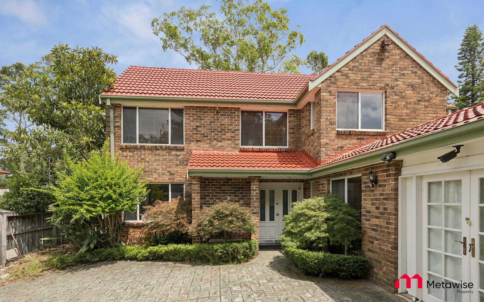 Front of a two-storey brick family home in Castle Hill that MetaWise manages, set in an established garden.