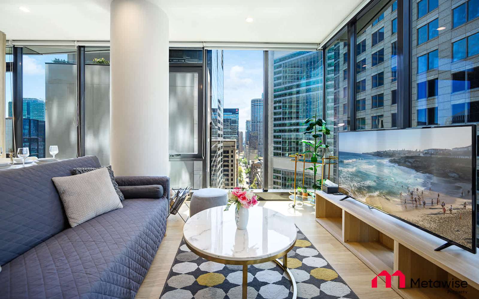 Living area of the York Street two-bedroom apartment, sofa and balcony with the city outside.