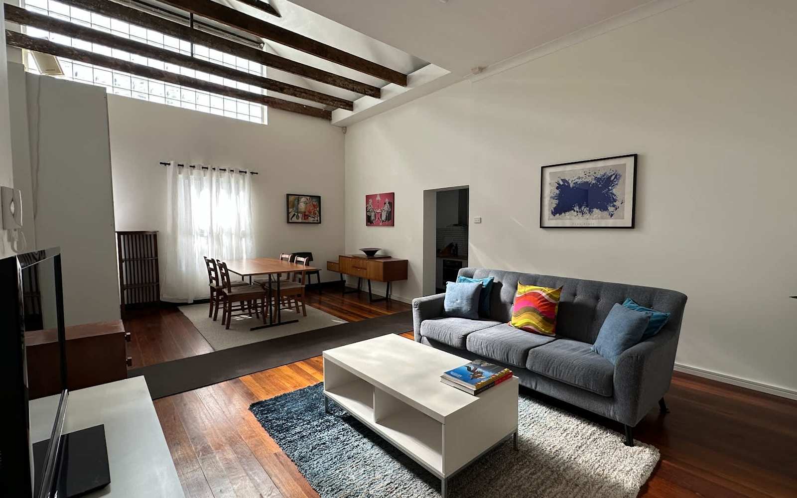 Living room of a MetaWise-managed two-bedroom apartment in Petersham, exposed beams and timber floors.