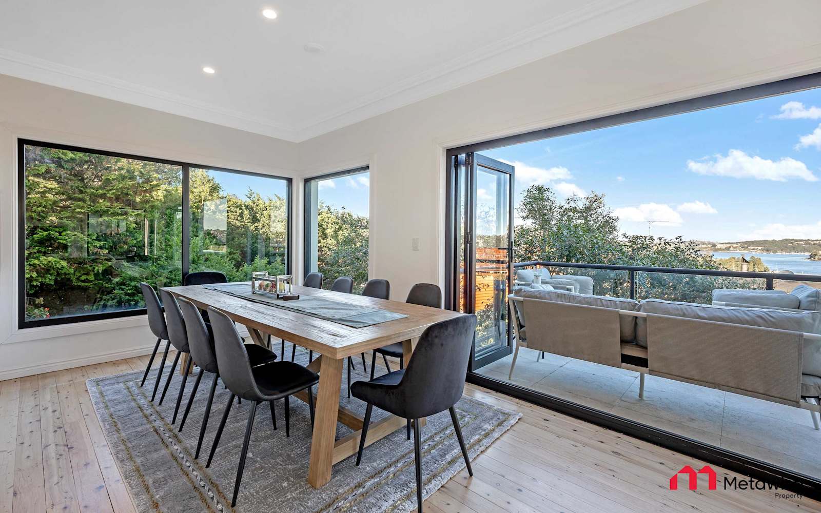 Dining room of the six-bedroom Seaforth home, sliding doors open to the balcony and the water.